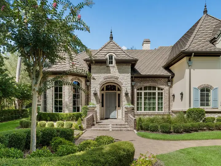 A stone and brick home entry with arched windows